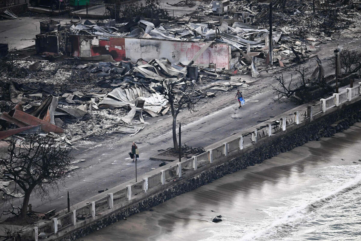An aerial image taken on August 10, 2023 shows a person walking down Front Street past destroyed buildings burned to the ground in Lahaina in the aftermath of wildfires in western Maui, Hawaii.