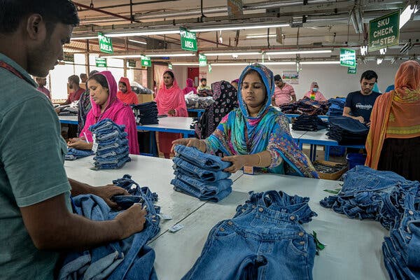 Workers at a garment factory make and  fold denim overalls. 